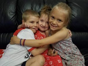 Photo of siblings; a little boy and two girls