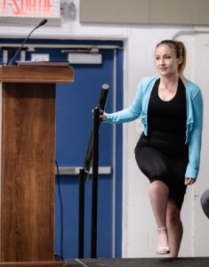 Alumnae Speaker Sarah walking onto the stage Grad 2025